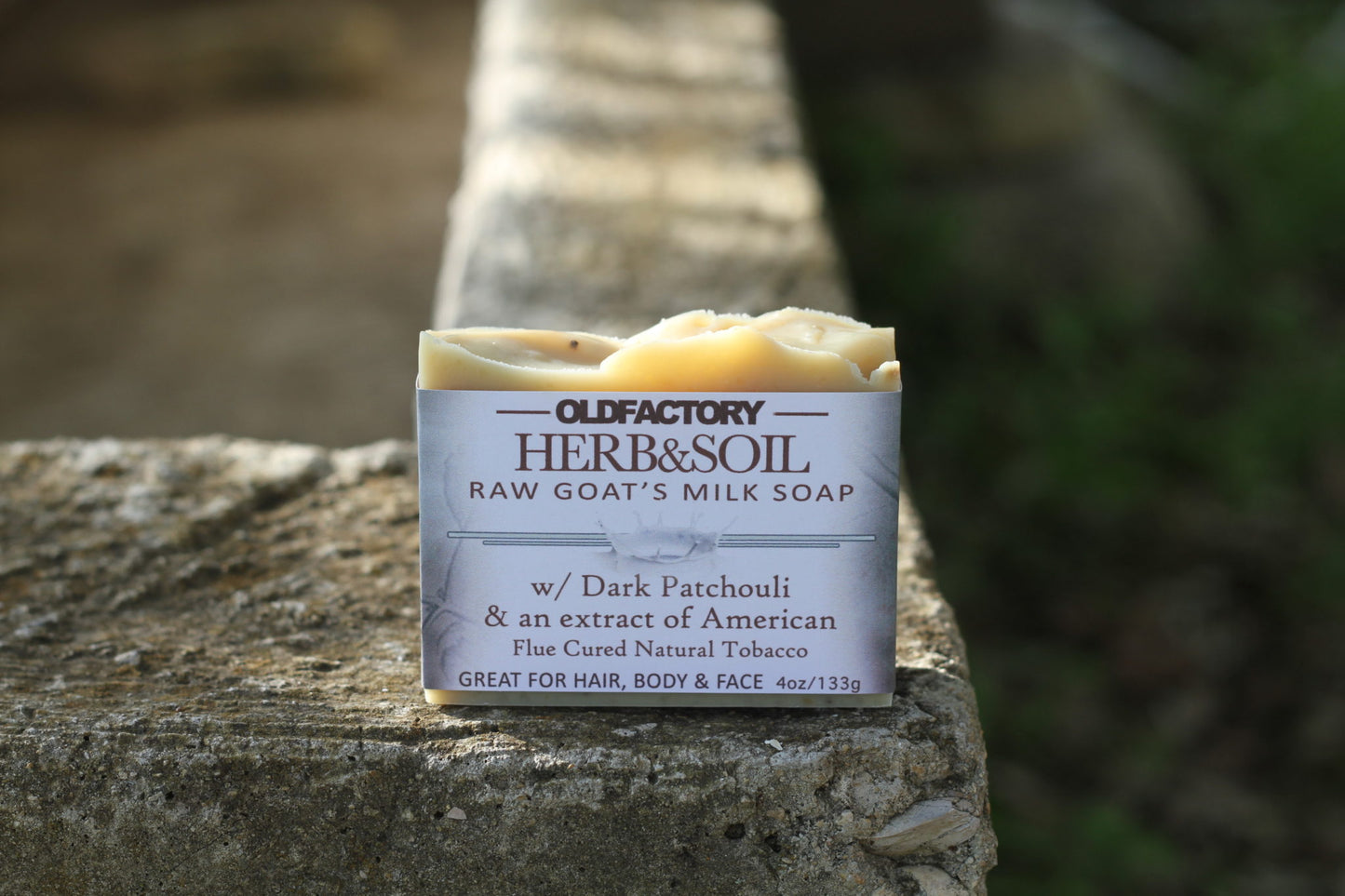 the healthy promise soap handcrafted goats herb and soil shampoo bar front side on a stone wall