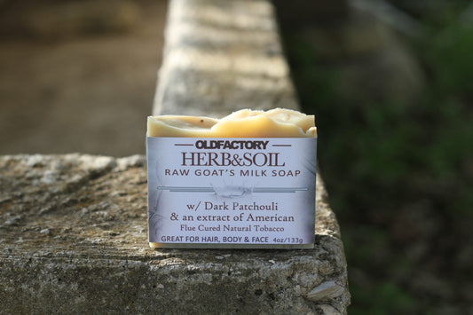 the healthy promise soap handcrafted goats herb and soil shampoo bar front side on a stone wall