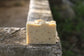 the healthy promise soap handcrafted goats herb and soil shampoo bar back side on a stone wall