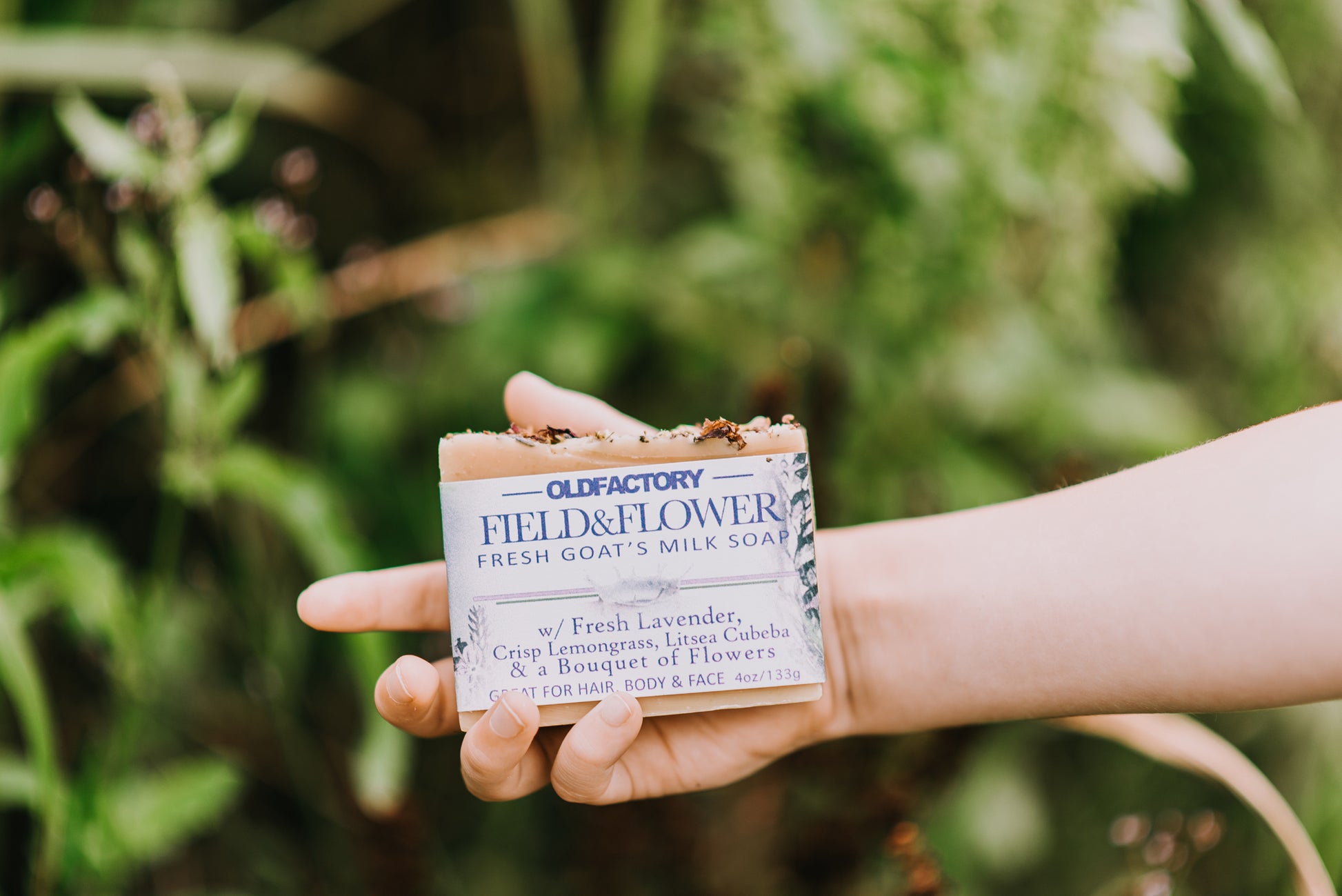 the healthy promise soap handcrafted goats milk field and flower in a persons hand